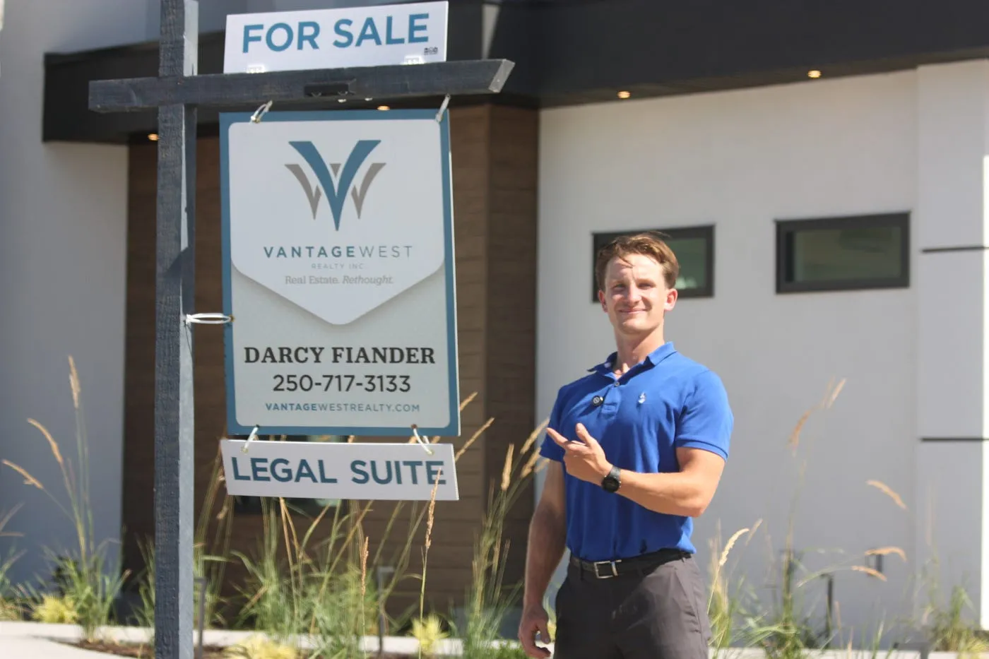 Max Treble beside one of his signposts on a Kelowna listing